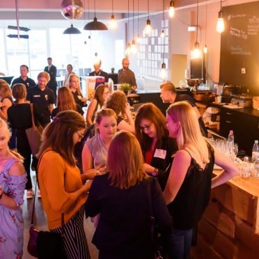 BayFiD Teilnehmerinnen stehen an einem Tresen beisammen und unterhalten sich in lockerer Atmosphäre