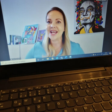 Laptop-Bildschirm der Videokonferenz mit Julia Bangerth groß im Bild und weiteren Teilnehmer*innen klein darüber