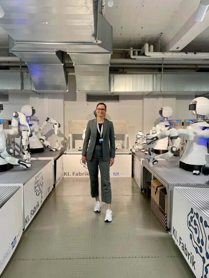 Johanna in einem Raum mit humanoiden Robotern