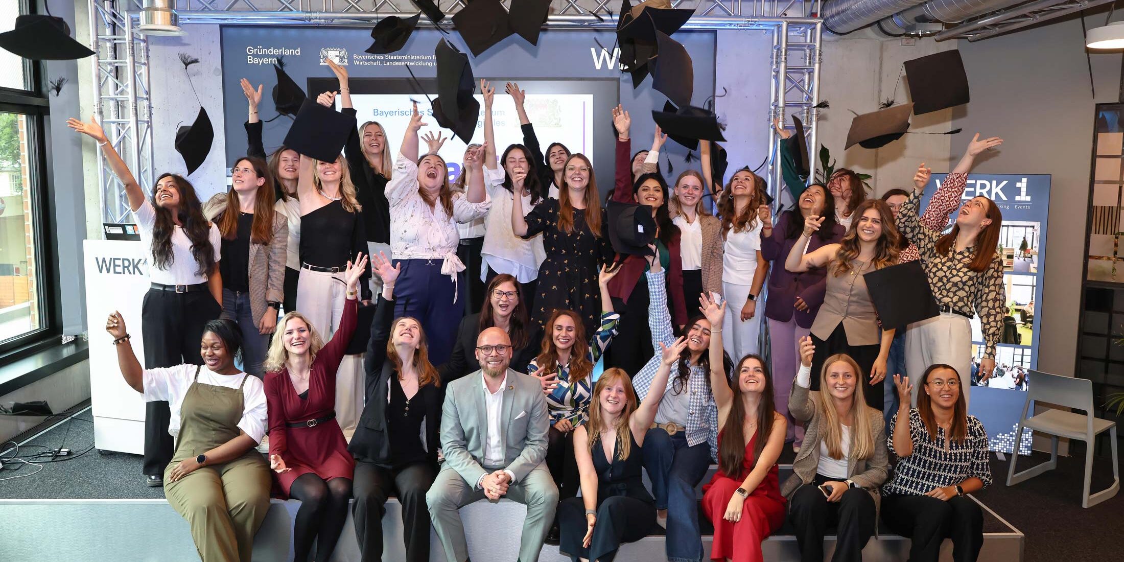 Gruppenbild der BayFiD-Talente von Batch 5, die ihre Hüte hochwerfen